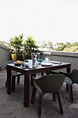 Black plastic outdoor chairs and set table on roof terrace