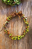 Wreath of rose hips on rustic wooden background