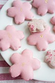 Flower-shaped biscuits with pink icing on plate