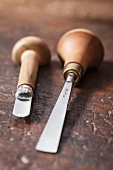 Two woodworking tools with wooden handles on rustic wooden surface