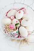 Easter eggs decorated with napkin decoupage in nest of straw in wire basket