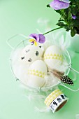 Easter arrangement; eggs decorated with washi tape and feathers in basket