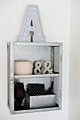 Ornaments in shades of grey and black in small, open-fronted shelf unit