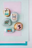 Paperweights made from painted pebbles decorated with butterfly postage stamps