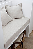 Bench with linen cushions and rattan basket