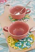 Pink cups on patterned coasters made from oilcloth remnants