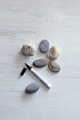 Collections of pebbles and felt-tipped pen on wooden surface