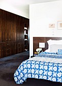 Bed room with blue and white bed linen; corridor with fitted wardrobes in dark wood to one side