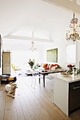 Dog on wooden floor, kitchen island and dining area in vintage, open-plan, country-house-style interior