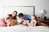 Happy family playing on bed