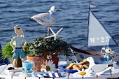 Biscuits on plate surrounded by maritime ornaments on white table against ocean backdrop