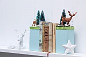 Hand-crafted bookends with winter motifs decorated with miniature deer and tiny fir trees