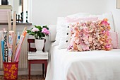 Scatter cushions with ruffles in shades of pink on couch with white blanket