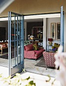 View from terrace through open lattice doors into interior with antique sofa and armchairs