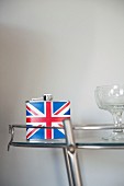 Hip flask with Union Flag motif and cocktail glasses on glass side table