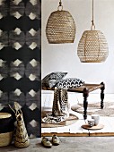 Natural materials and modern, African print curtain with graphic, black and white pattern, basketwork lampshades and bench with turned legs and fabric strap seat