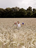 Two girls walking through a wheat field