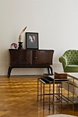 Minimalist, retro living room furnishings with sideboard and nest of delicate tables on herringbone parquet floor