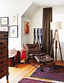 Sessel und Fussschemel mit braunem Lederbezug auf Orientteppich neben Vintage Stehleuchte in traditionellem Wohnraum