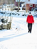 Woman and dog on snowy street in Scandinavia