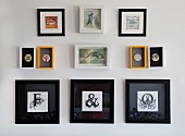 Framed initials in black frames below small pictures of animals and badges on wall