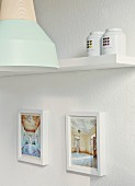 Framed photos of house interiors, tea caddies and metal lamp with wooden bulb socket by young designer