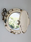 Vintage porthole built into house wall with view into garden