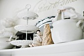 Cake stand made from white, china plates, small figurine and pot on shelf