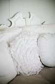 Scatter cushions with white covers, some pleated or ruffled
