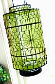 Patterned, wire mesh lantern with green, transparent sheath inside