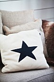 Pale scatter cushion with black star motif on sofa