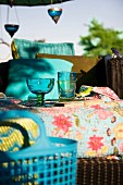 Table decorated with coloured glasses on patterned tablecloth outdoors