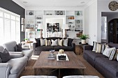 Sofa set around wooden coffee table in front of white, fitted shelving