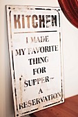 Vintage metal sign with motto leaning against wall