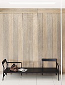 Designer bench made from dark wood against wood-panelled wall