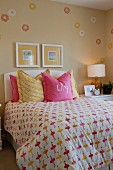 Bett mit Kissen & verspielter Bettwäsche in Pink & Gelb in Mädchenzimmer