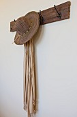 Detail of hat and scarf on coat rack on wall; San Marcos; California; USA