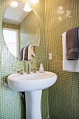 Bad mit grünen Mosaikfliesen, Waschbecken & ovalem Badspiegel