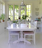 White dining table and chairs in dining room with white wooden floor