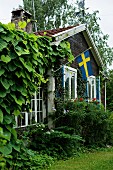 Rustic wooden house with Swedish flag on terrace