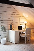 Vintage-style home office below wood-clad sloping ceiling; gable-end wall made from whitewashed wooden beams