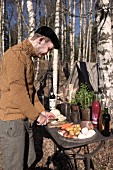 Man chopping vegetables on table in woods
