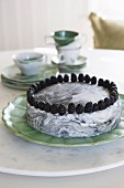 Marbled cake topped with blackberries on marble lazy Susan on dining table