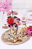 Silver cutlery & flower arrangement in shades of pink on silver tray