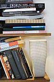Many books and designer lamp on floating shelves