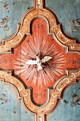 Antique ceiling ornament with religious theme in wood-panelled dining room