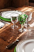 Rustic stem ware and green felt place mats on set farmhouse table