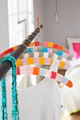 Colourful, stripped crocheted covers for hangers on a clothes rack