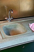 Küchenarbeitsplatte und Spüle aus Beton mit recycelten Messingplatten als innovativen Spritzschutz