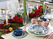 Blue and white place setting with napkin and amaryllis centrepiece on table set for Christmas dinner